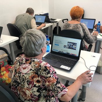 Seniorzy siedzący przy komputerach