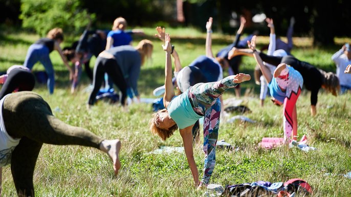  - Ludzie uprawiający jogę na trawniku w parku