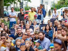 Ludzie siedzący na trawniku i leżakach