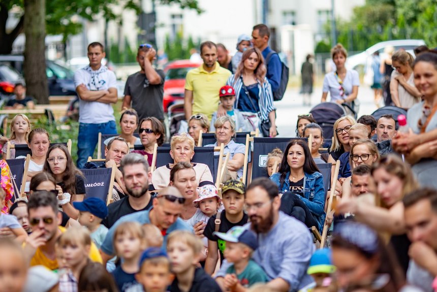 Ludzie siedzący na trawniku i leżakach