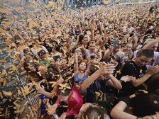 Ludzie bawiący się w tłumie pod sceną główną na Łódź Summer Festival 2023. Z nieba spada confetti.