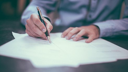 Grafika przedstawiająca osobę podpisującą dokument
