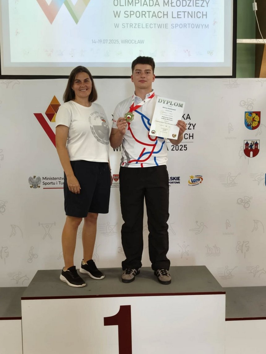 Mariusz Radzikowski z trenerką na podium po zdobyciu złotego medalu młodzieżowych mistrzostw Polski