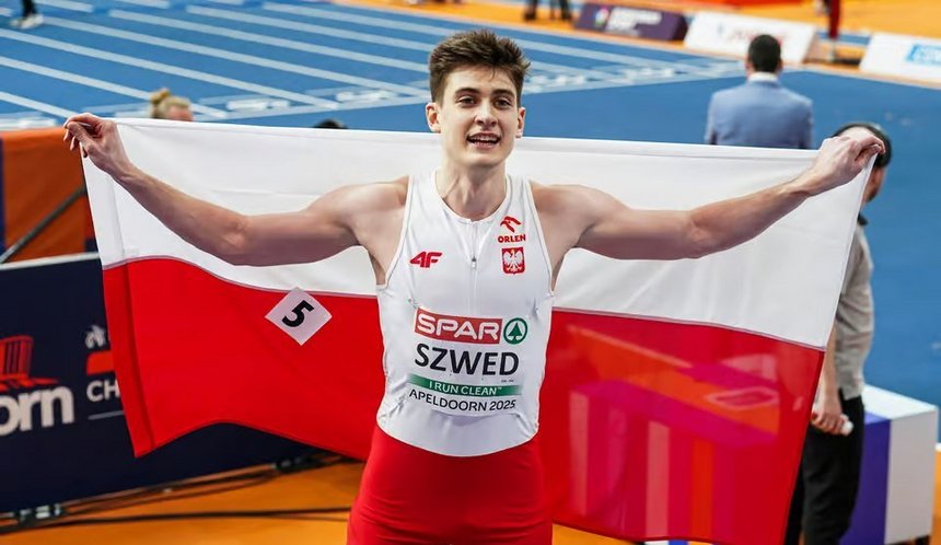 Maksymilian Szwed pozujący do zdjęcia z Polską flagą