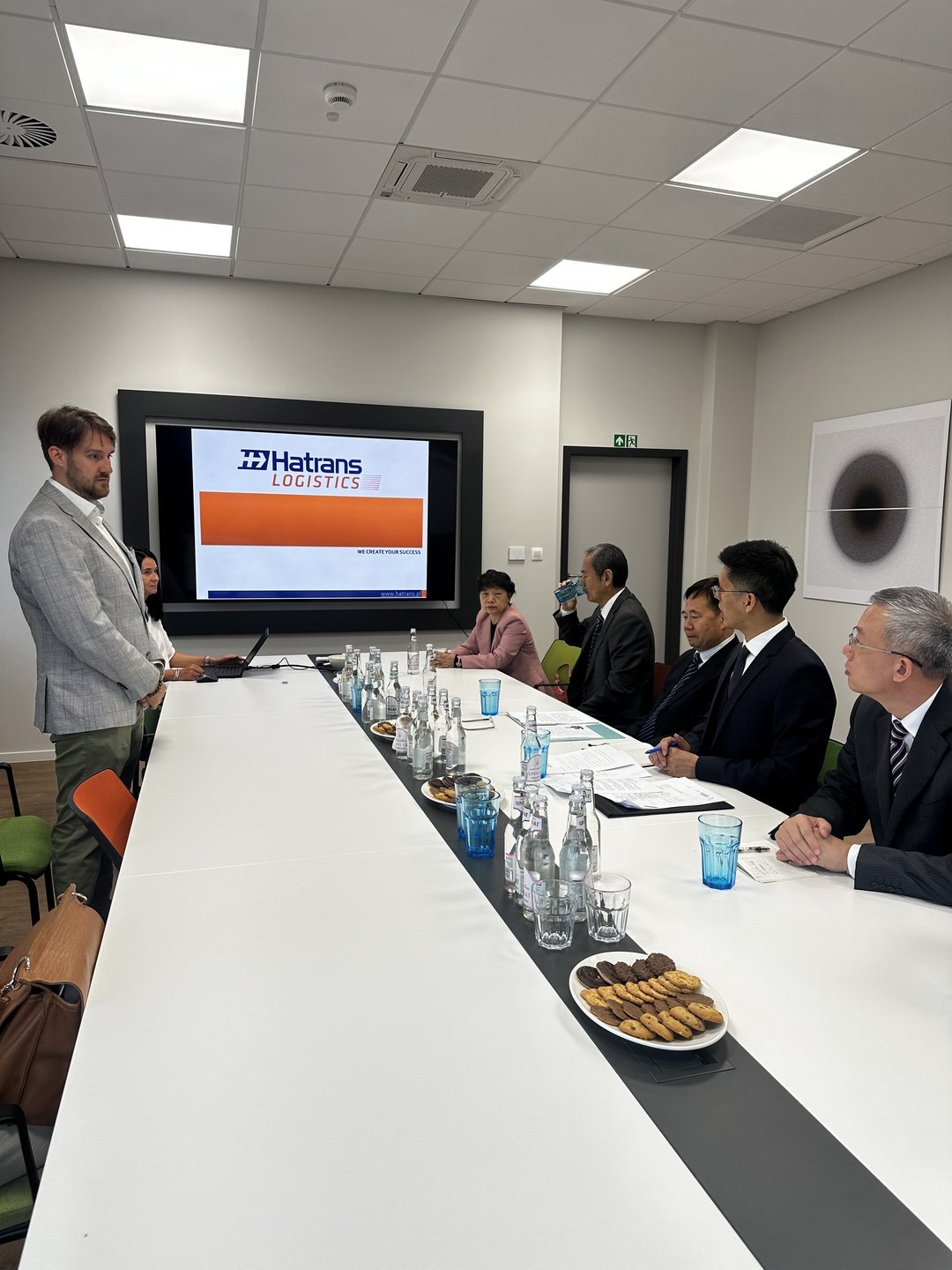 Przedstawiciele Miasta Kanton siedzący przy stole podczas prezentacji firmy Hatrans