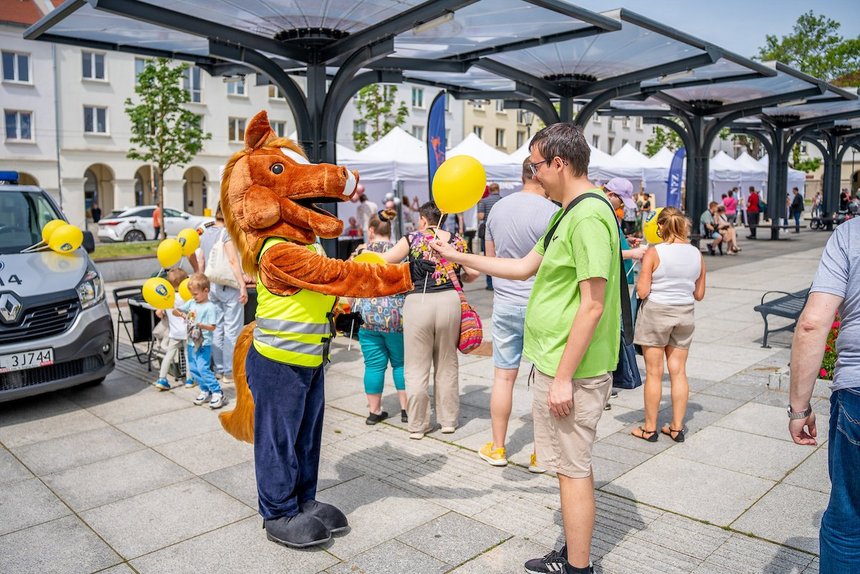 Strażnik miejski w stroju maskotki sekcji konnej - Konika przebija piątkę z uczestnikiem pikniku