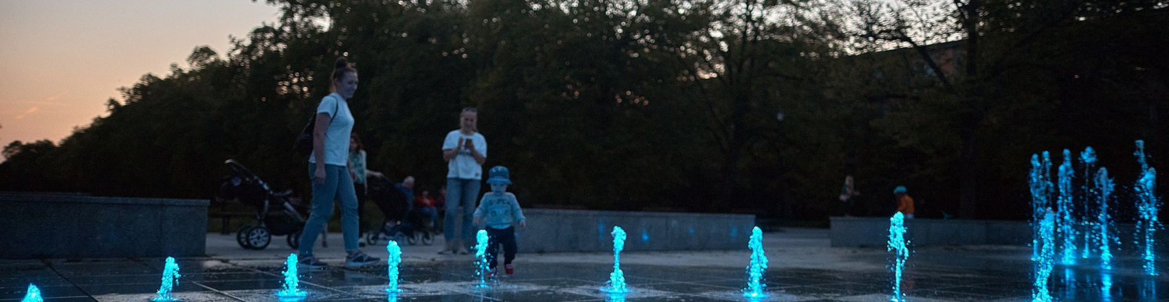  , Fontanny multimedialne w Parku Poniatowskiego świecące na niebiesko podczas zachodu słońca