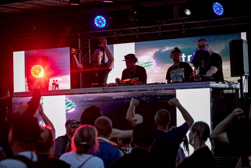 Na zdjęciu widoczna jest scena DJ-ów. Pod sceną ludzie bawiący się w tłumie