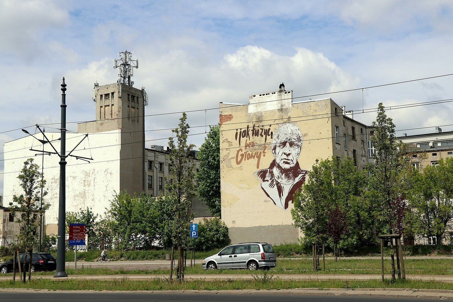 Mural na szczycie kamienicy, przedstawiający popiersie pisarza Janusza Głowackiego. Obok postaci widnieje napis "I jak tu żyć, bez Głowy?" 