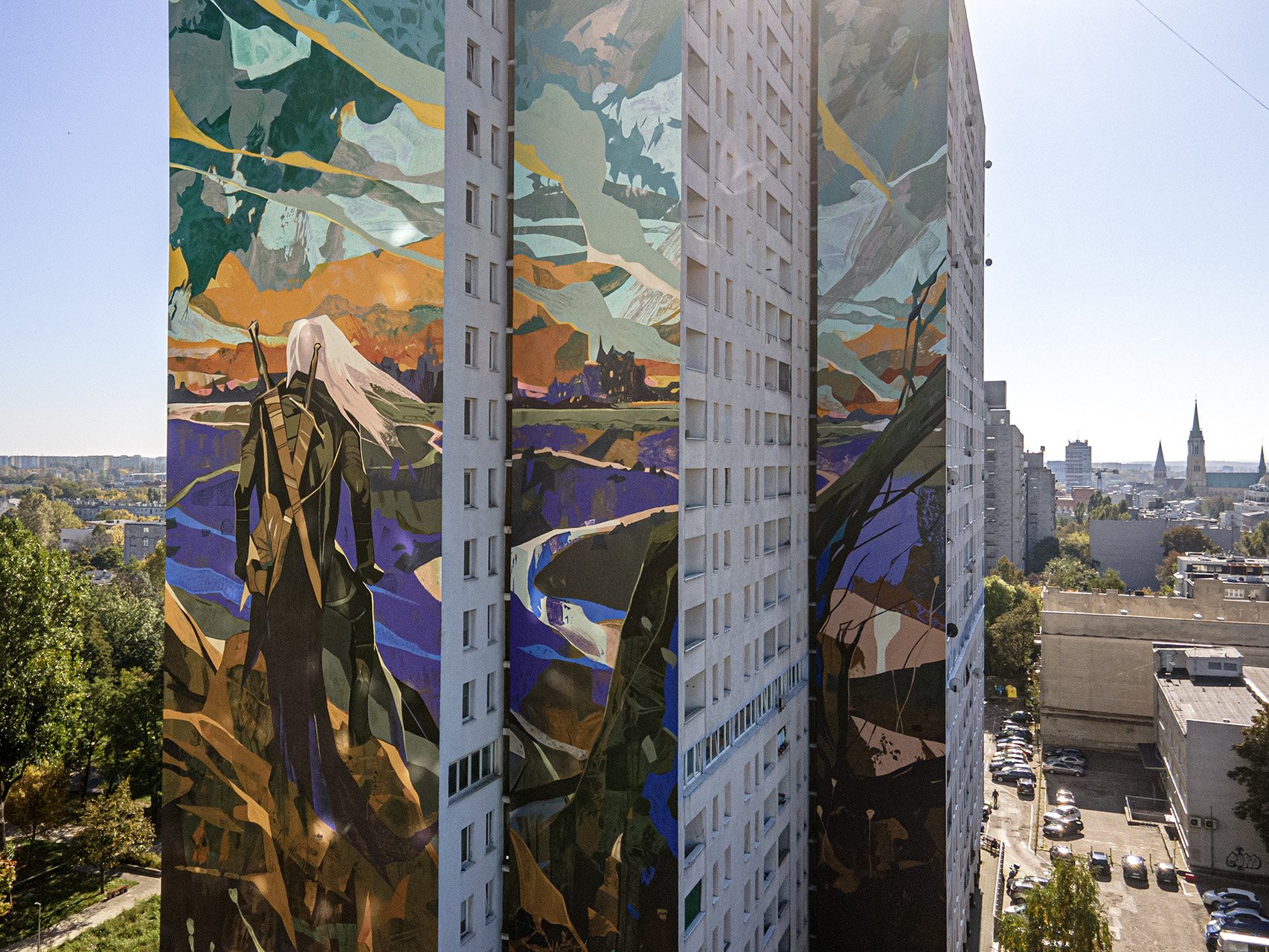  , Kolorowy mural przedstawiający postać Wiedźmina na szczycie wieżowca łódzkiego Manhattanu