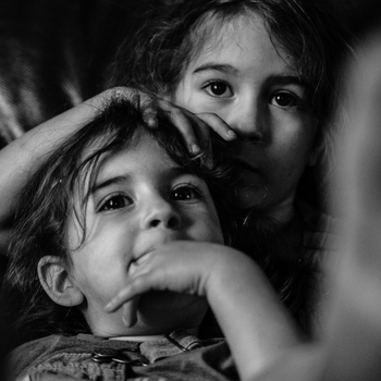 Czarno-białe zdjęcie przedstawiające twarze dwójki kilkuletnich dzieci.
