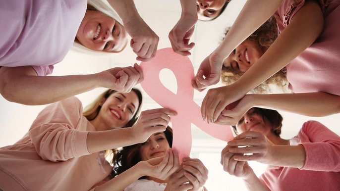 Women holding pink paper ribbon, bottom view. Breast cancer awar - V Kongres Onkologiczno – Kosmetologiczny