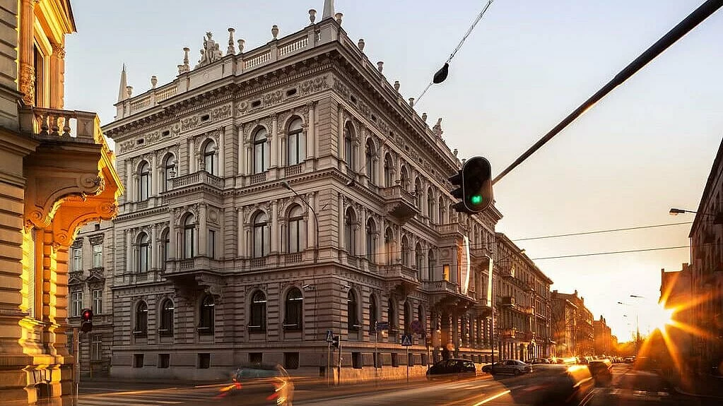 Zachód słońca. Skrzyżowanie ulicy Gdańskiej z Więckowskiego. Widok na zabytkowy jasny, trzypiętrowy budynek muzeum.