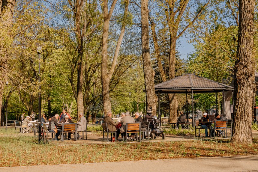 Ludzie siedzący przy stolikach i altanie w Parku Staromiejskim 
