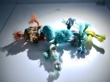 Kilka supłów z różnych kolorów sznurków połączonych ze sobą w jeden długi kawałek.