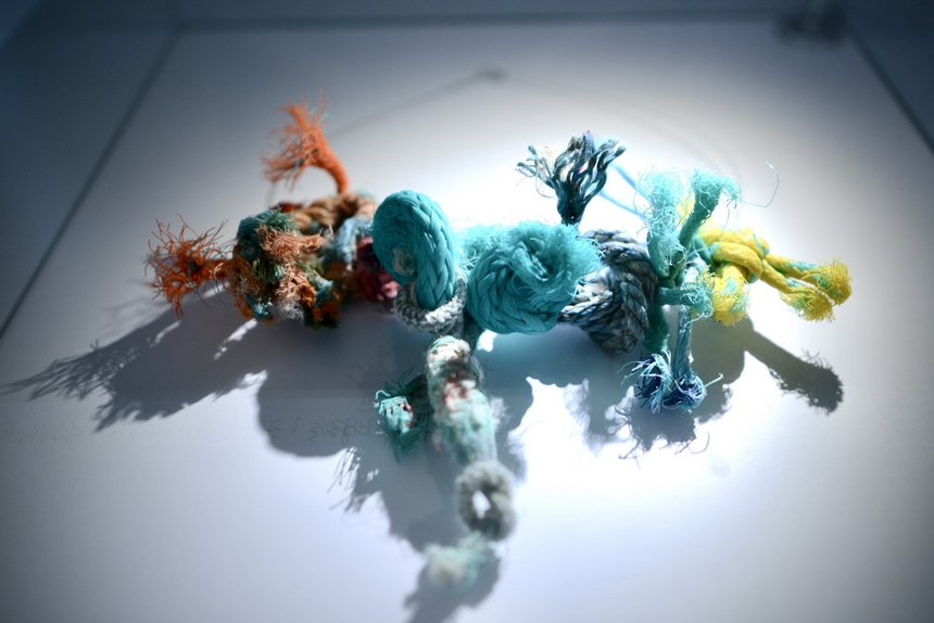 Kilka supłów z różnych kolorów sznurków połączonych ze sobą w jeden długi kawałek.